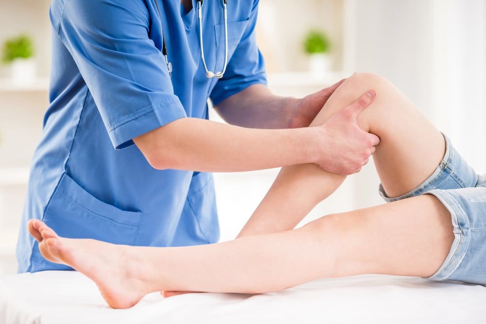 doctor holding patient leg stretching